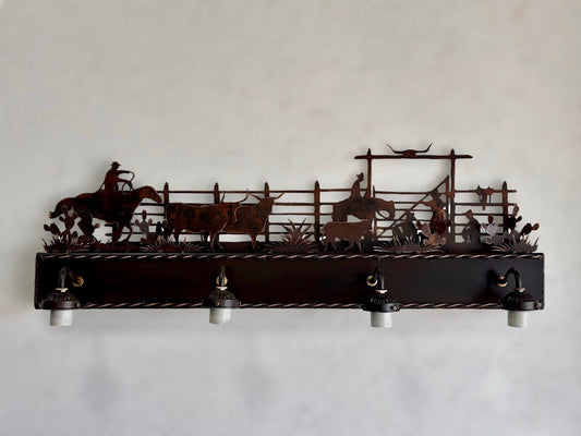 Western vanity light featuring cowboy,horse, and cattle in front of corral